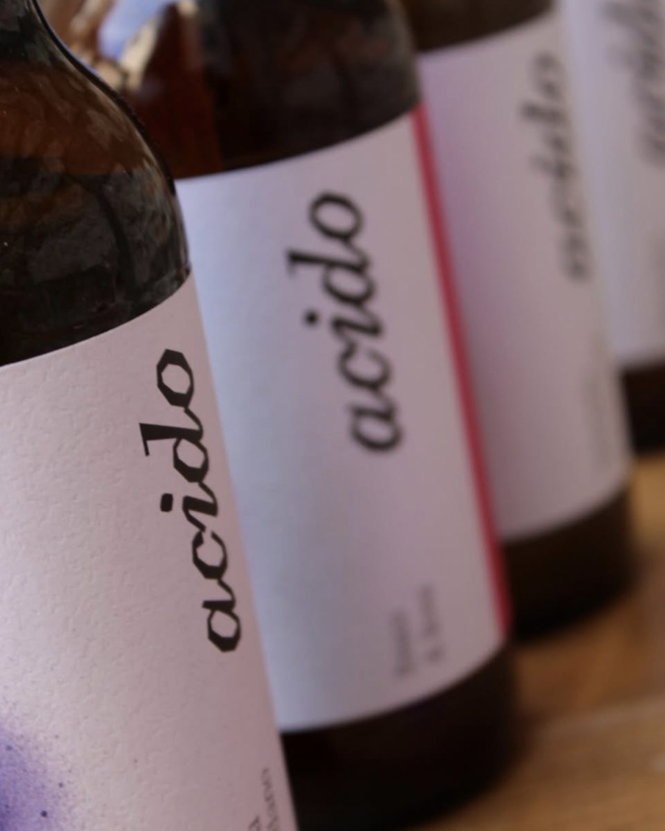 Bottiglie di kombucha Acido Lab in fila, etichetta bianca