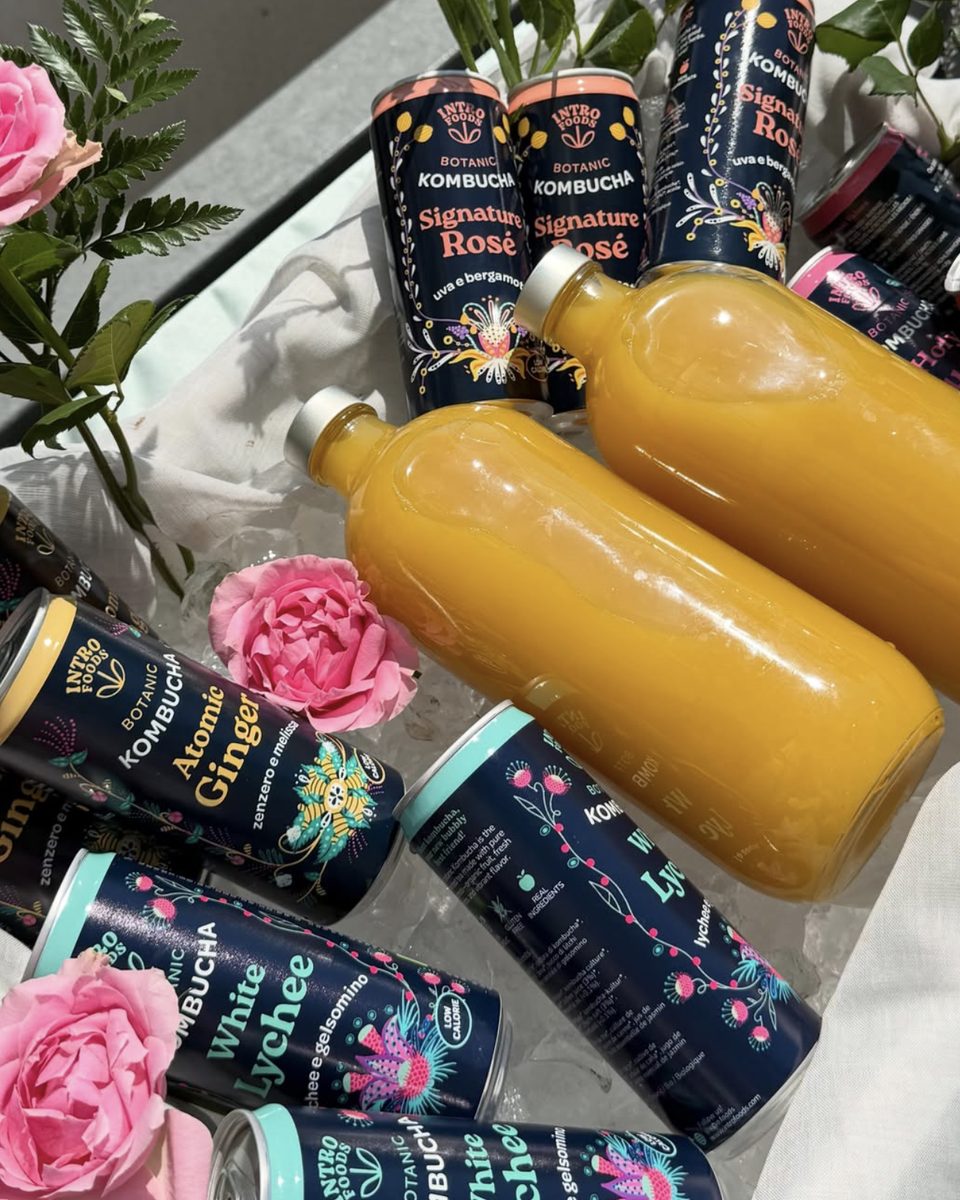 Lattine e bottiglie di Intro Kombucha nel ghiaccio, con rose