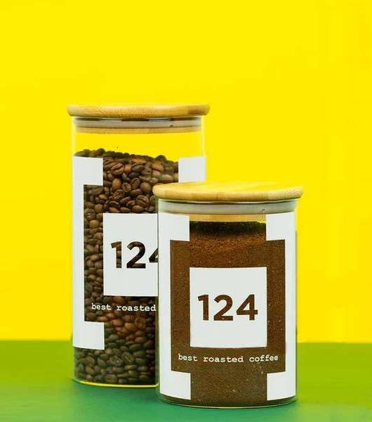 Due barattoli di caffè 124 su fondo giallo e verde