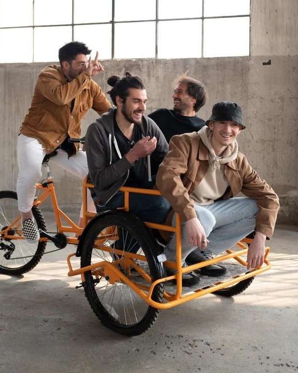 I quattro fondatori di Mia Kombucha su una cargo bike arancione